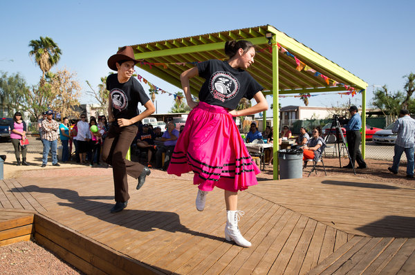 Two youths dance in a public square built by Kounkuey Design Initiative with local residents. The organization was co-founded by Chelina Odbert '99. Credit: Monica Almeida/The New York Times