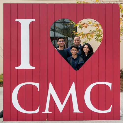 Family posing with a "I Love CMC" cutout sign during Family Weekend 2024.