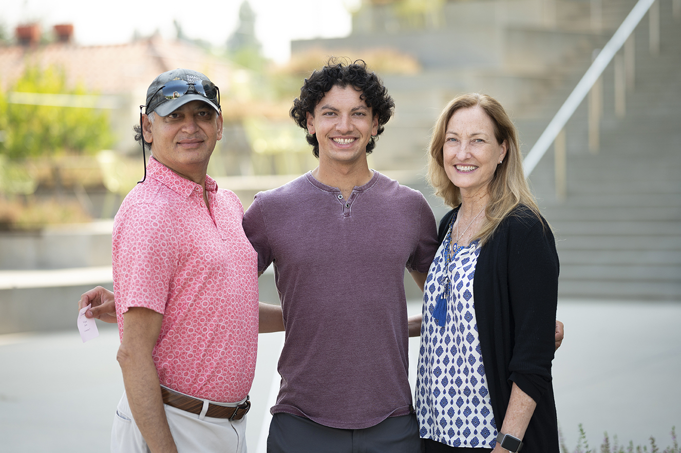 Vijay Jain ’24 poses with a big smile between his parents