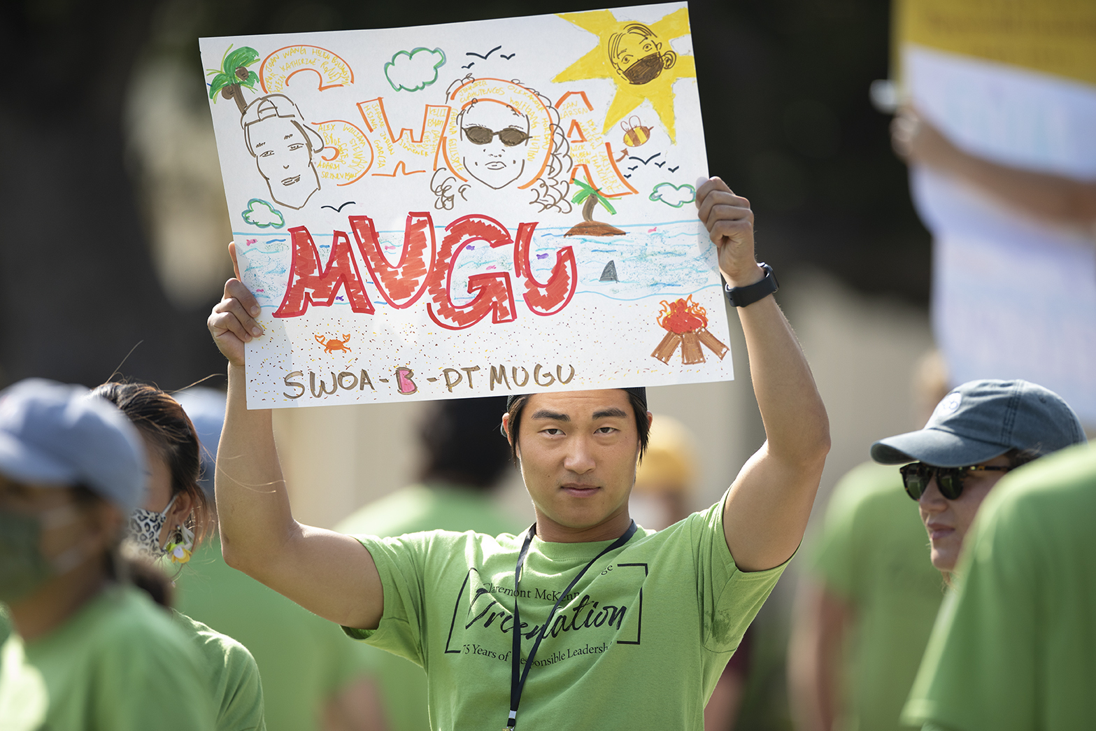 Robert Liu ’22 holds up a sign to help corral students at orientation