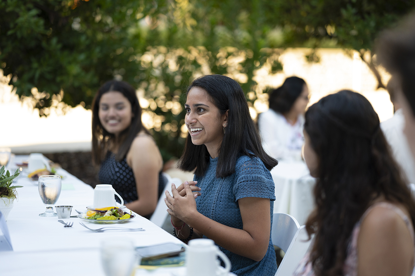 Maya Ghosh ’22 smiles while engaging in a group discussion with fellow student attendees, all seated at the first Ath dinner of the 2021 school year.