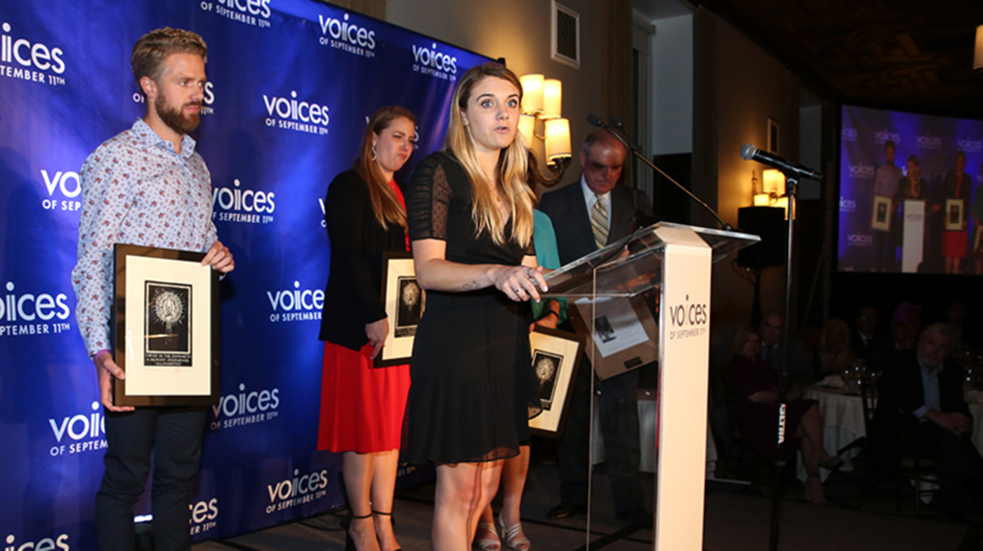 Heidi Wolfgruber ’11 stands at a clear podium for a VOICES event