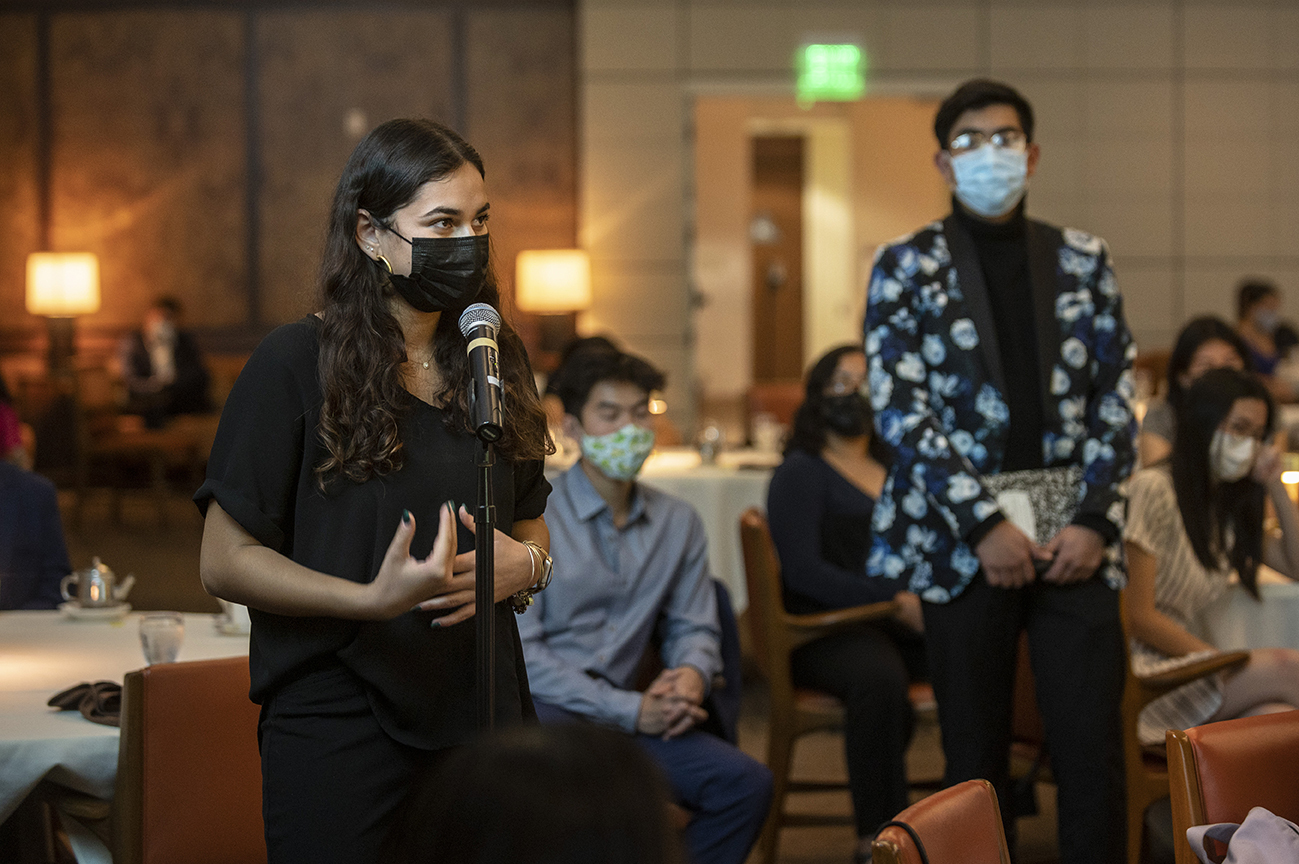 Inside the Ath halls, a masked participant asks guest speaker, France A. Córdova, a question.