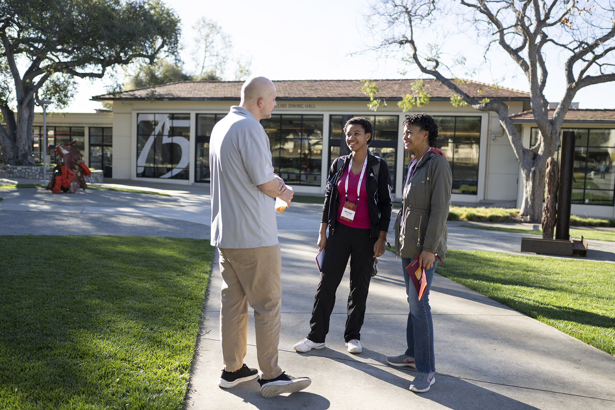 From left to right: Josh Meadows '21, Michaiah Young ’18, and LaTasha Young P'18 P'24 exchange words and smiles outside Collins.