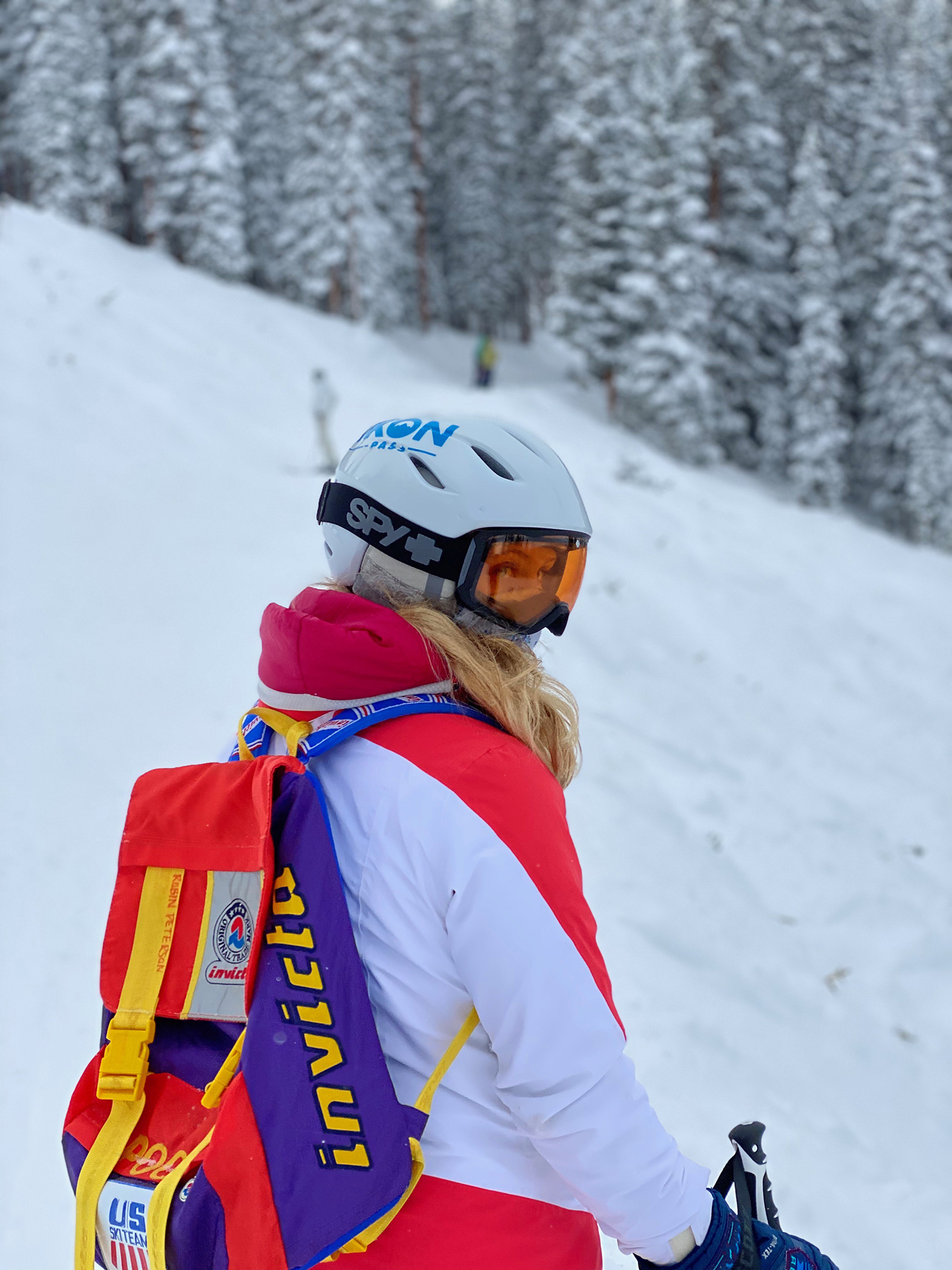 Robin Peterson '22 in brightly colored snow gear at a white peak.