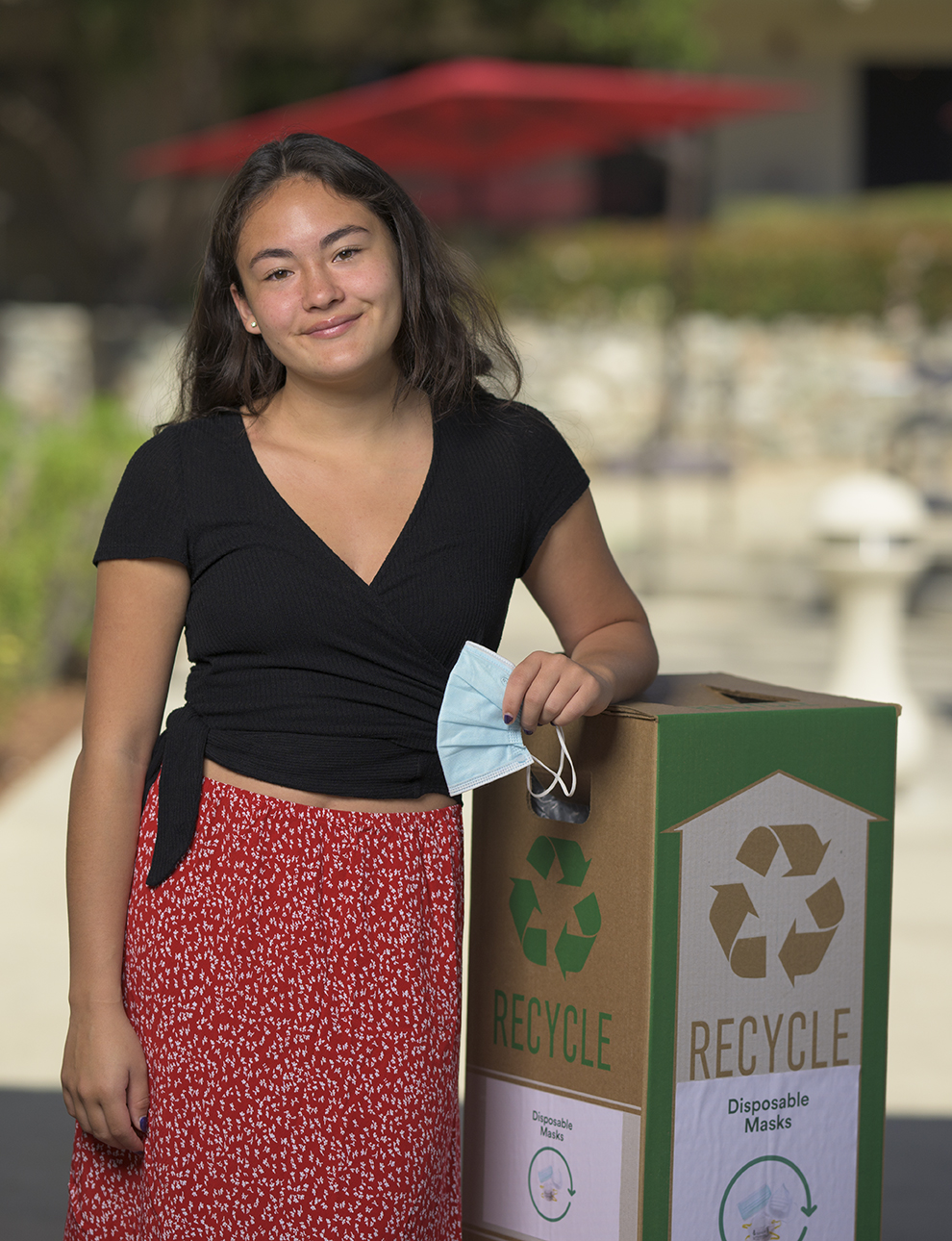 Portrait of Nicole Jonassen '24 standing by her mask recycling collection bin.
