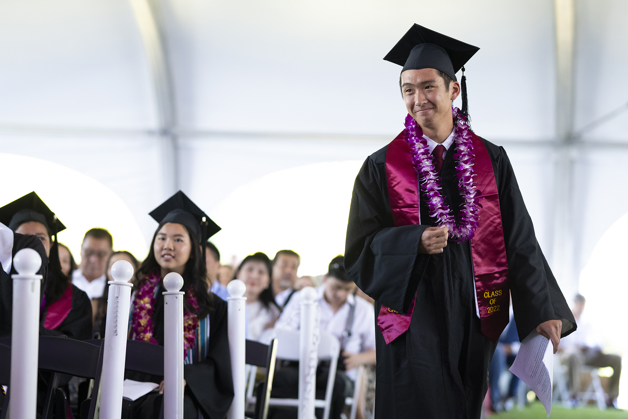 Jayson Yasukochi ’22, Class-Elected Speaker, approaches the stage from his seat with his printed speech in hand.