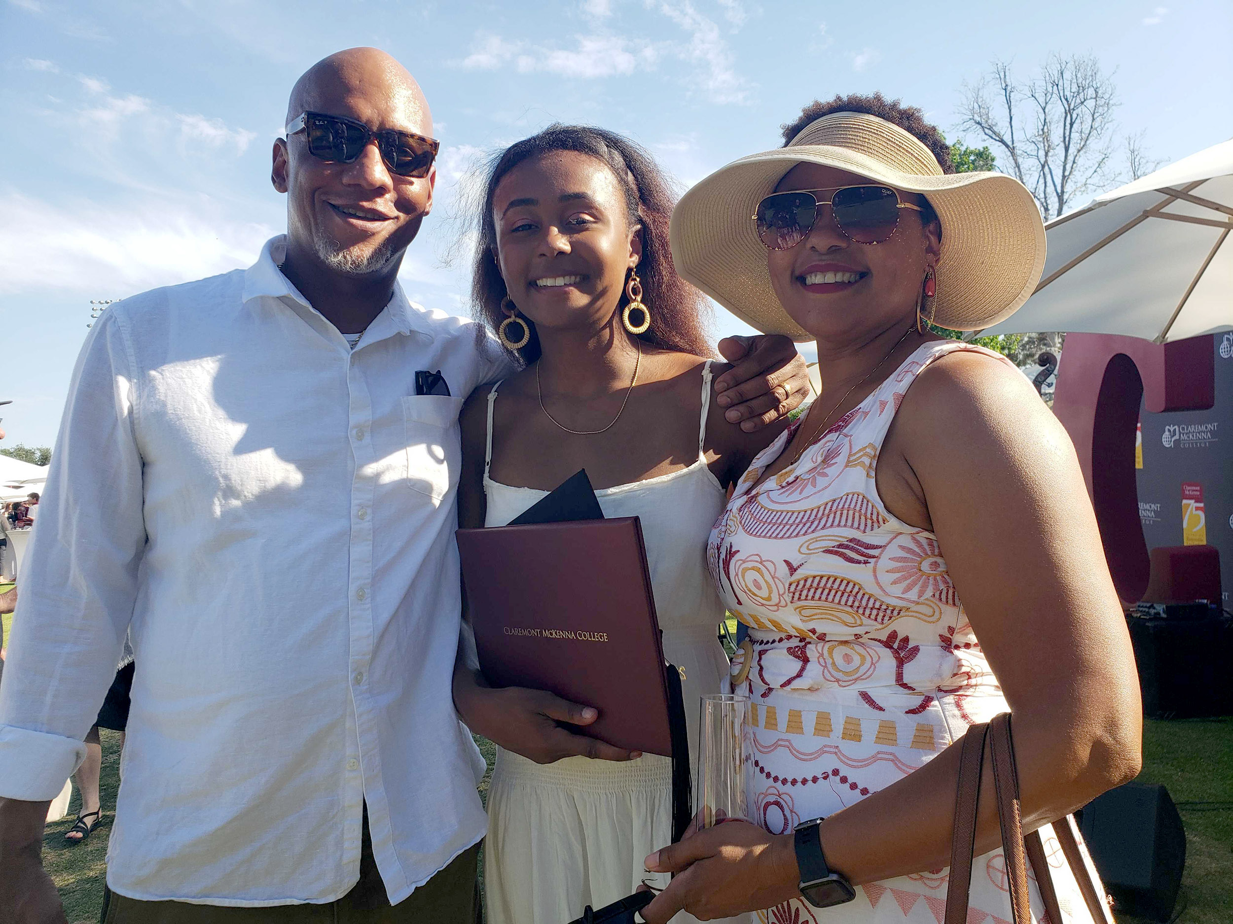 Sydney Ross '22 stands between her parents with her diploma in hand at CMC's 2022 Commencement.