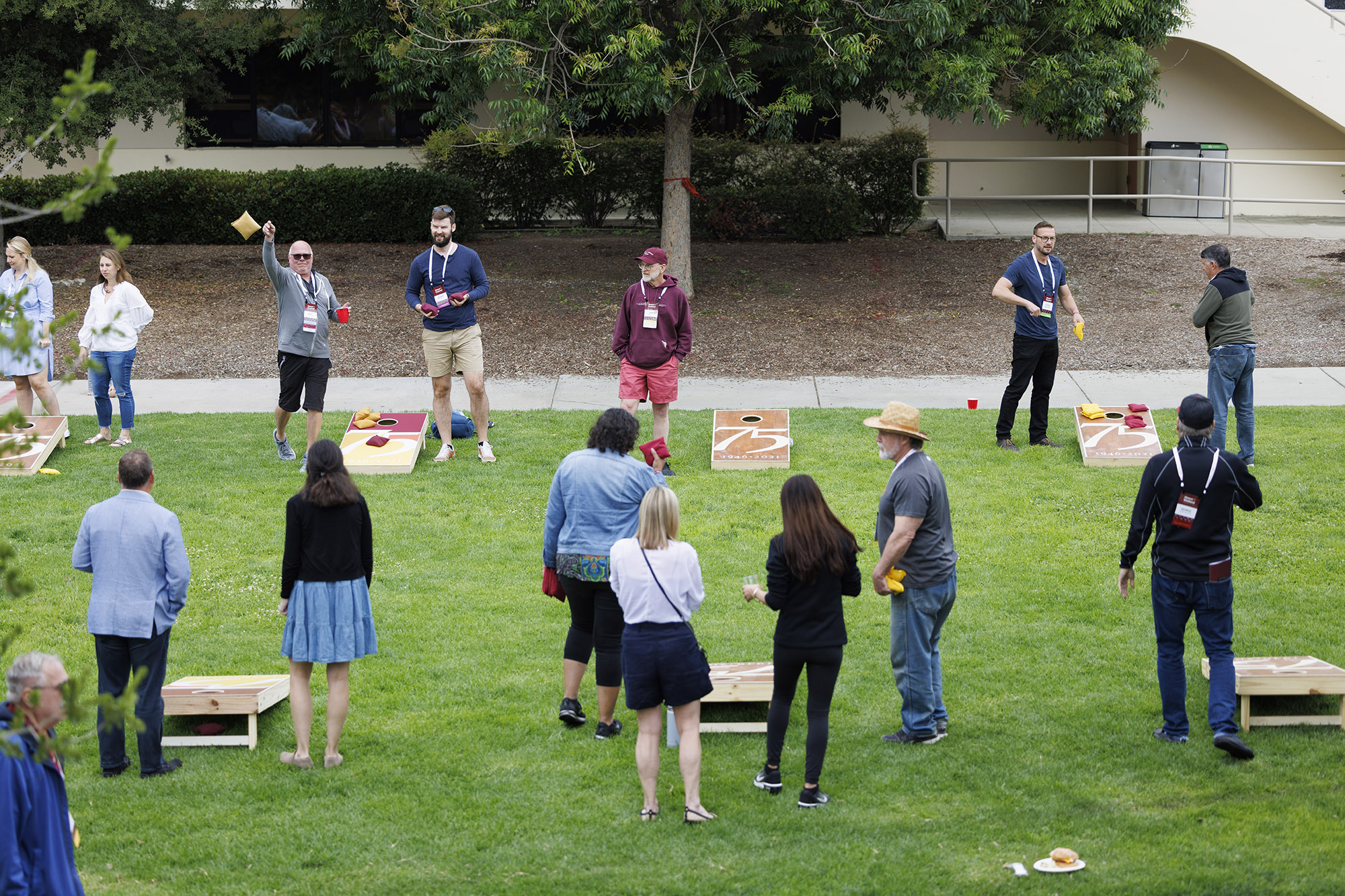 Friends and family of CMC alumni enjoy a cornhole tournament on the lawn during the second day of 2022 Alumni Weekend.