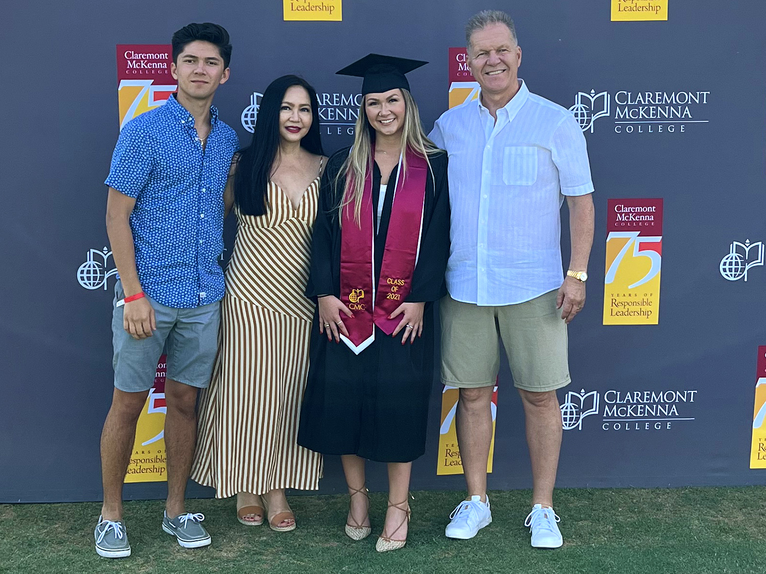 Brielle Huddy ’21 photographed together with family against a gray CMC 75th Anniversary logo pattern backdrop.