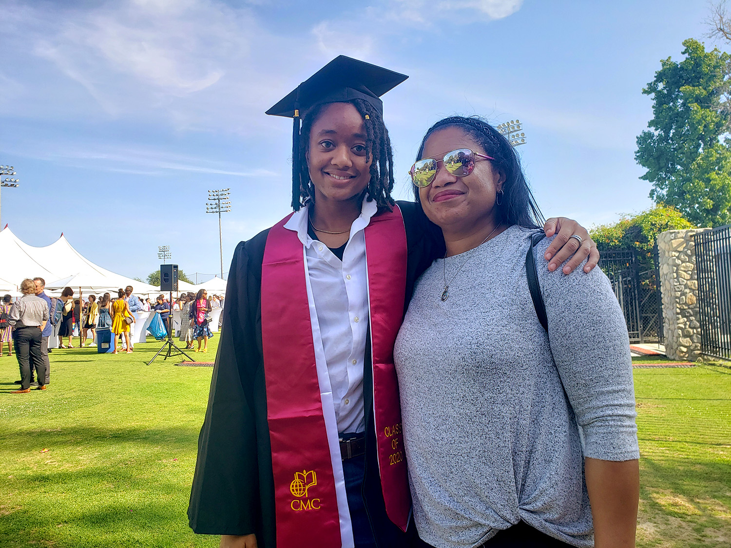 Judah Bates ’20 stands outside on Parents Field with an arm around her mother on CMC's Celebration Weekend for the Classes of 2020 and 2021.