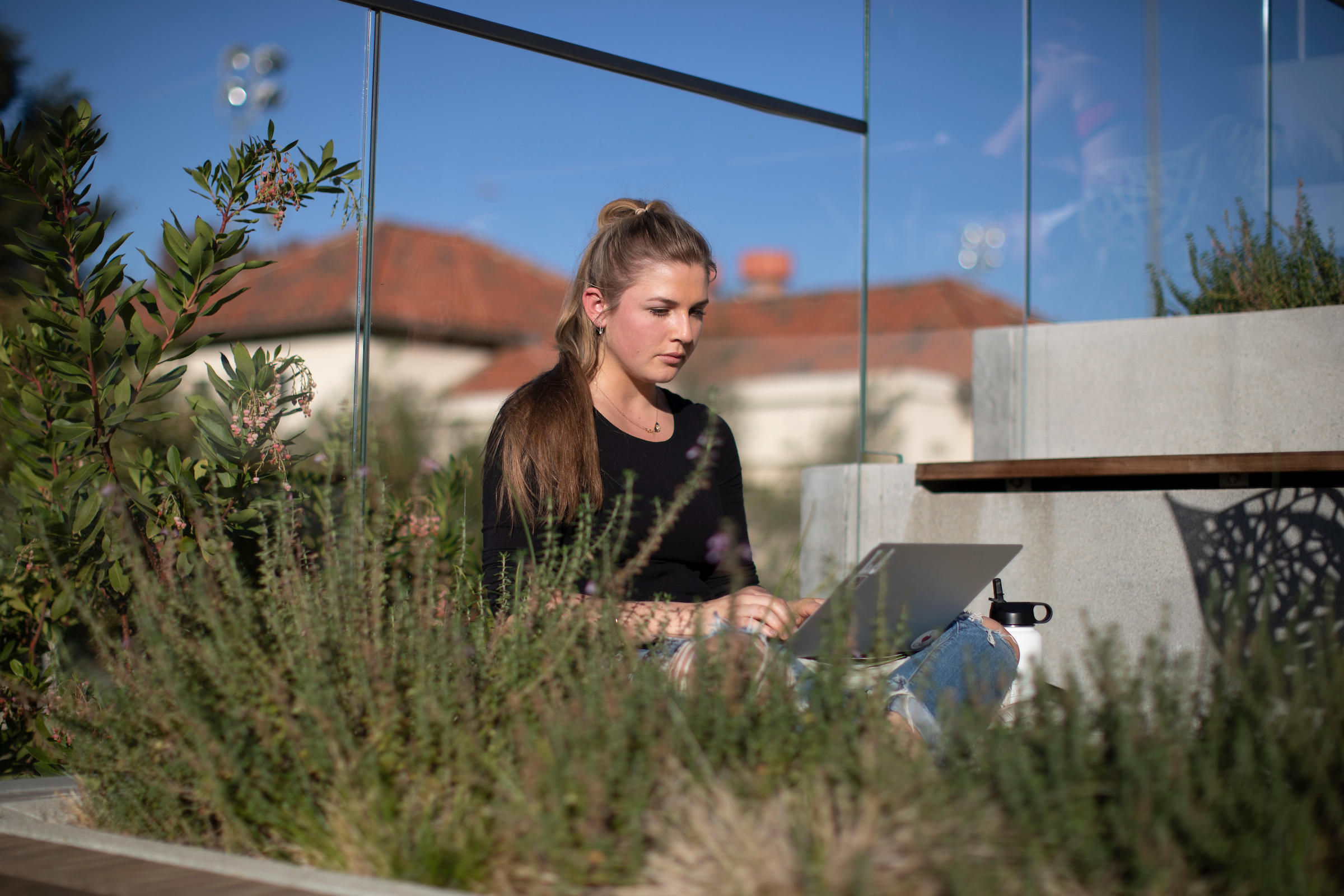 Student working on laptop on campus