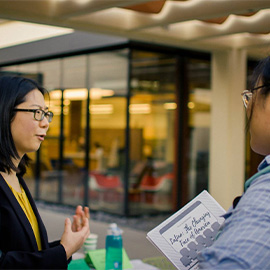 Professor Wang speaks with a student at a 2017 preregistration event.