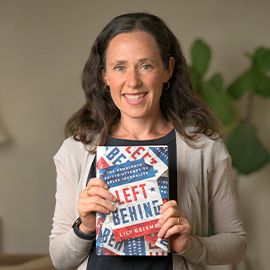 Professor Geismer holds up her newly published book, Left Behind.