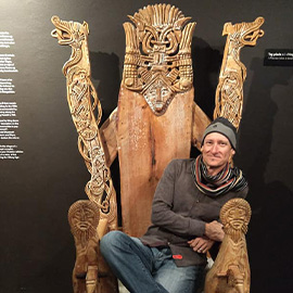 Professor Bjornlie seated on an ornately carved wooden throne at the National Archaeological Museum in Copenhagen.