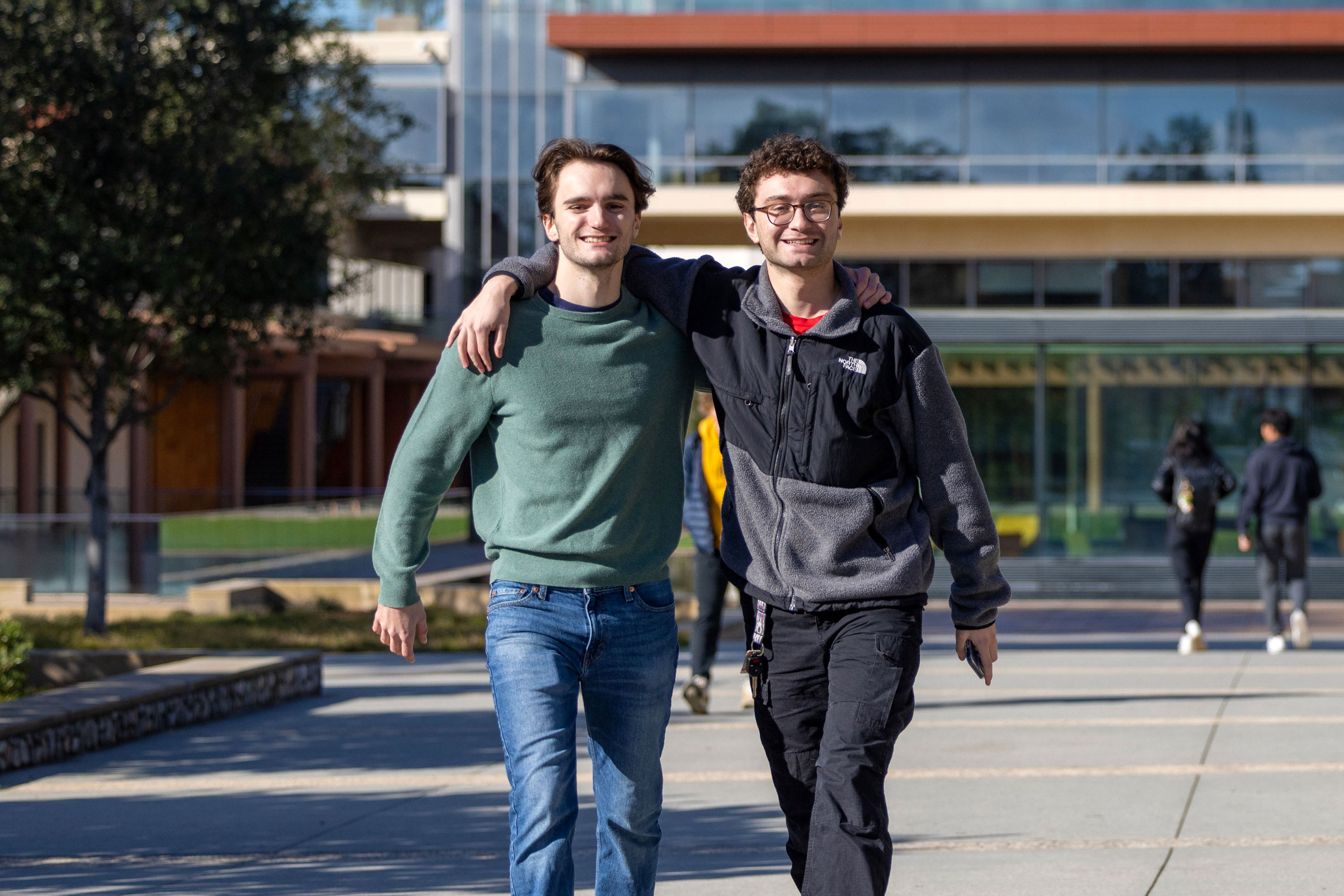 Two friends walking together on the first day of classes in front of Kravis Center.