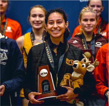 Natalie Bitetti '24 holding a trophy after competing in NCAA Division III Championship races for the CMS women's cross country team.
