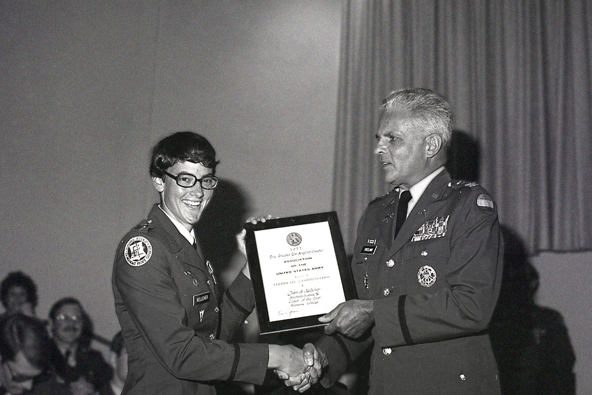 Historical photo of female student receiving a certificate from ROTC.