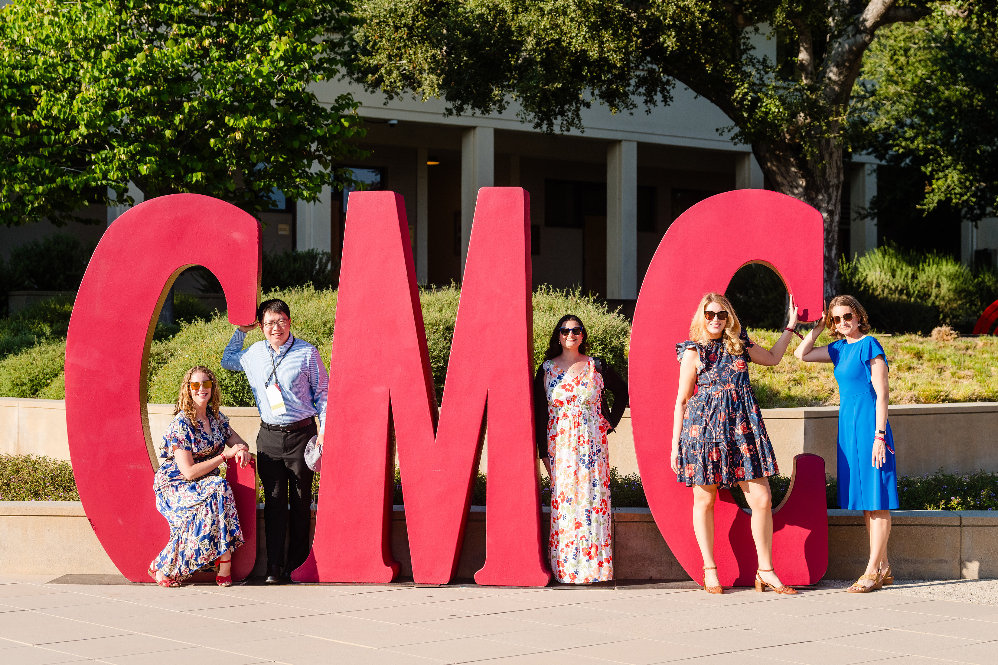 CMC alumni playfully pose around life-sized photo props