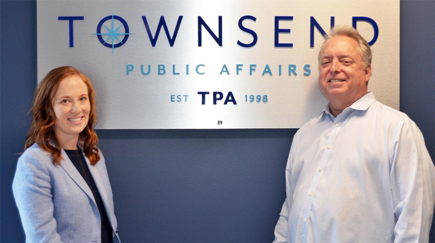 Cori Takkinen ’11 and Christopher Townsend ’82 in front of the Townswnd Public Affairs sign.