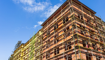 A view of a scaffolded building from the street. 