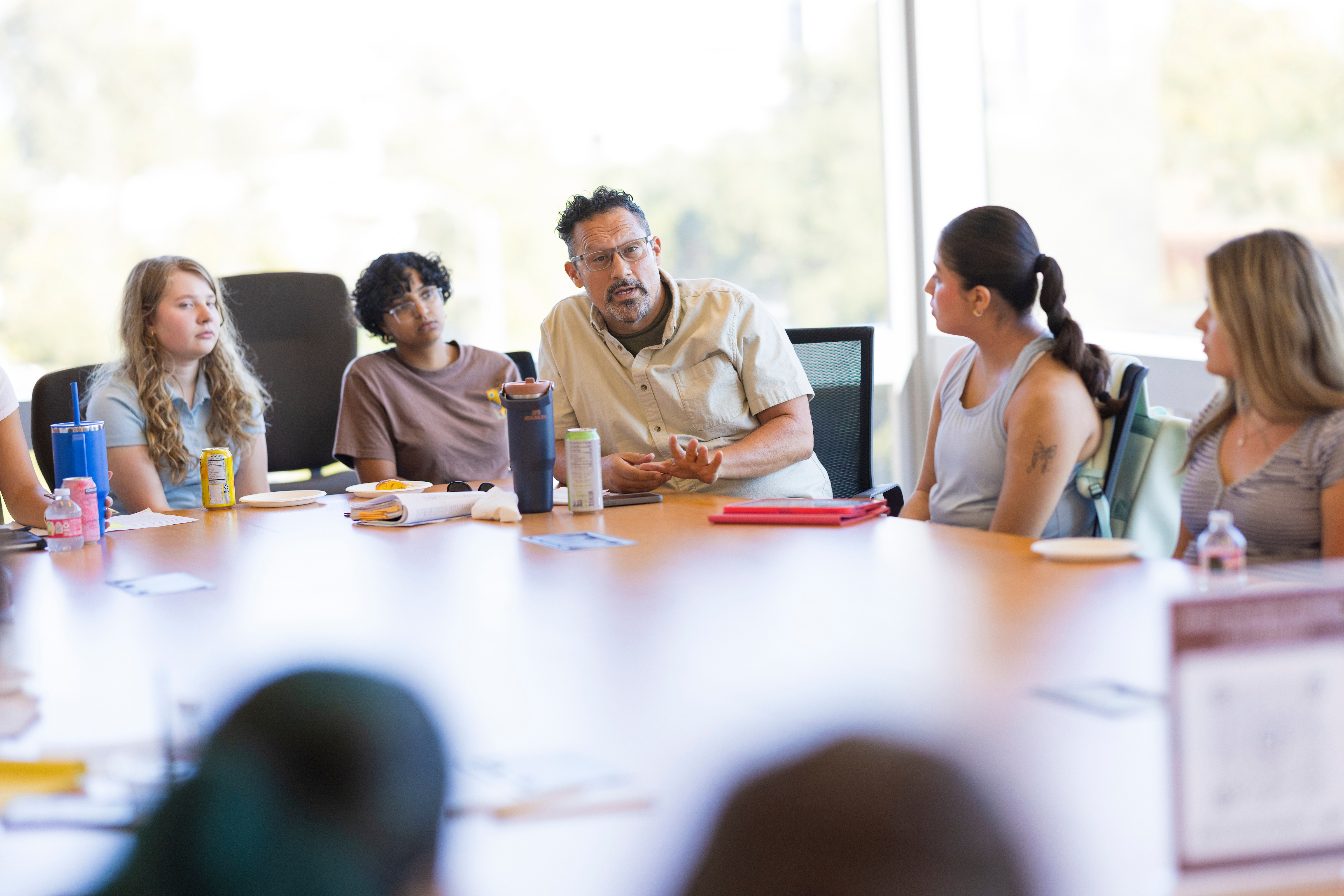 Students discussing with a professor inside a classroom.