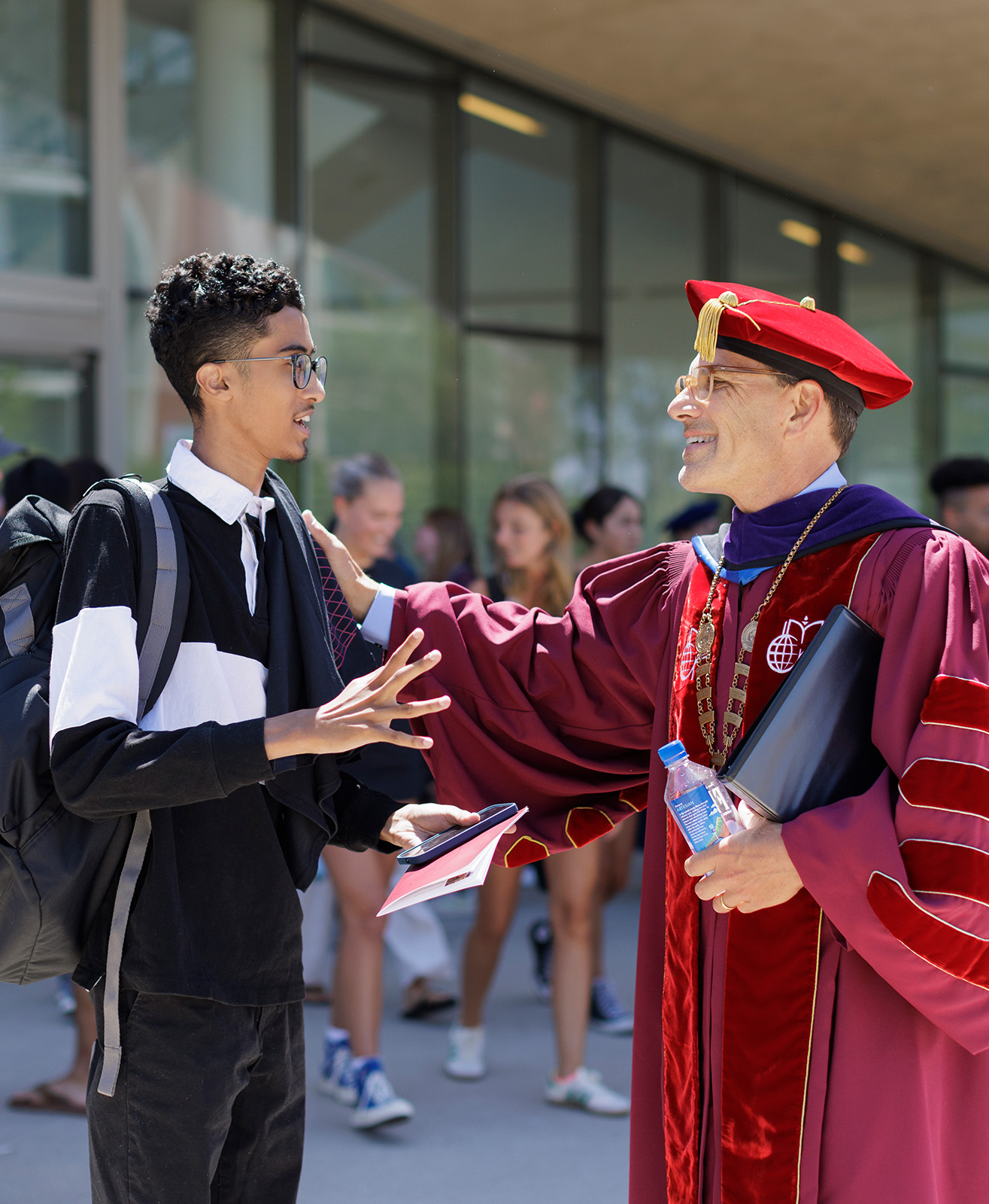Hiram speaking with a student outside Roberts Pavilion.