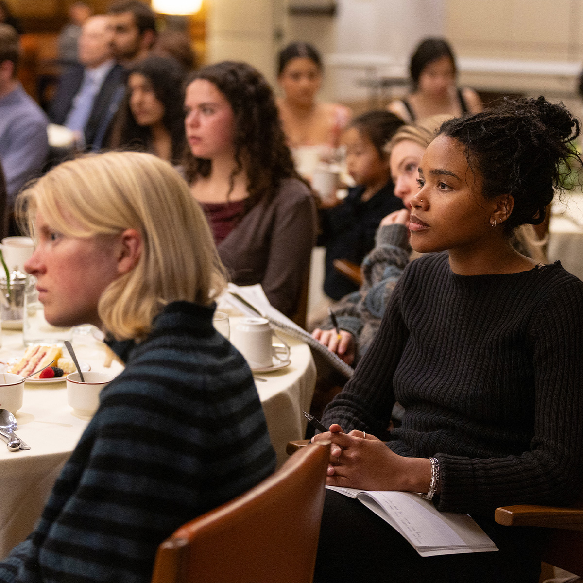 Two students listen intently during an Athenaeum talk.