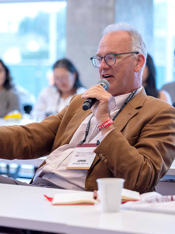 An alumni member speaking from the audience during a panel.