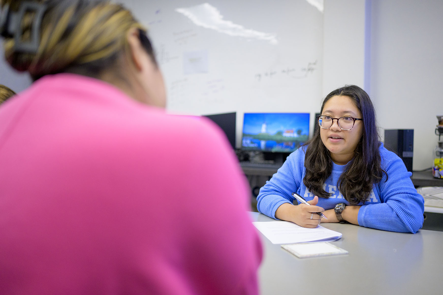 Two students working at table.