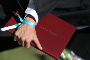 A graduate wears a blue ribbon to honor the memory of Tamar Kaplan '14.