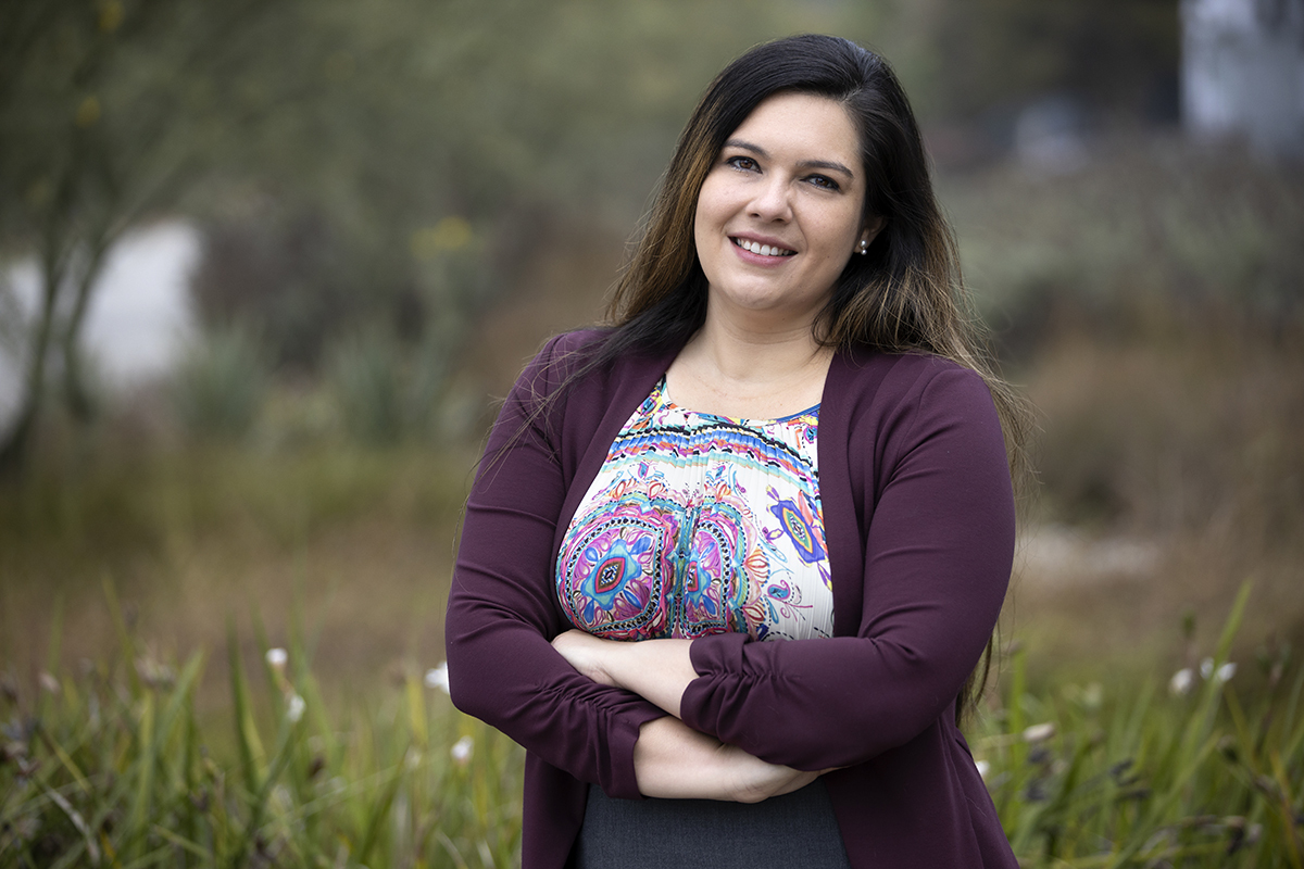 Assistant Professor Jennifer Feitosa photographed outdoors with flowers