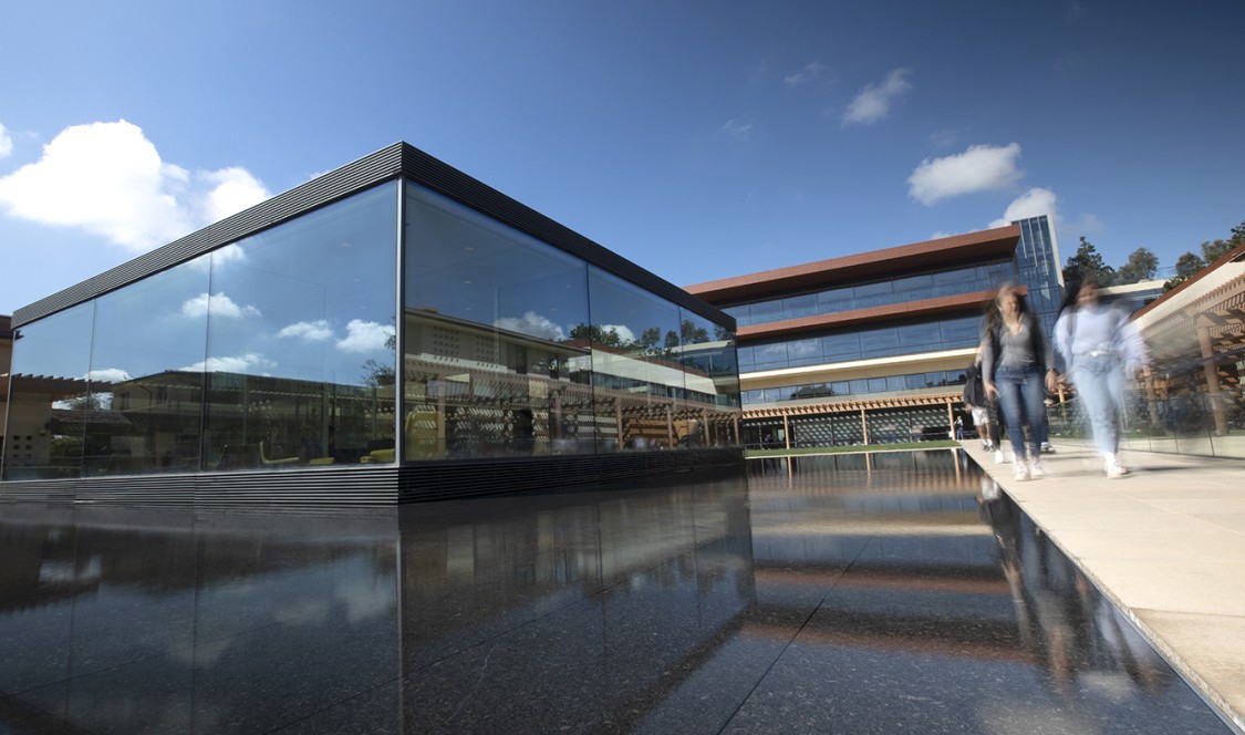 One of CMC's two architectural landmarks, "the Cube," stands in front of the Kravis Center as students walk by