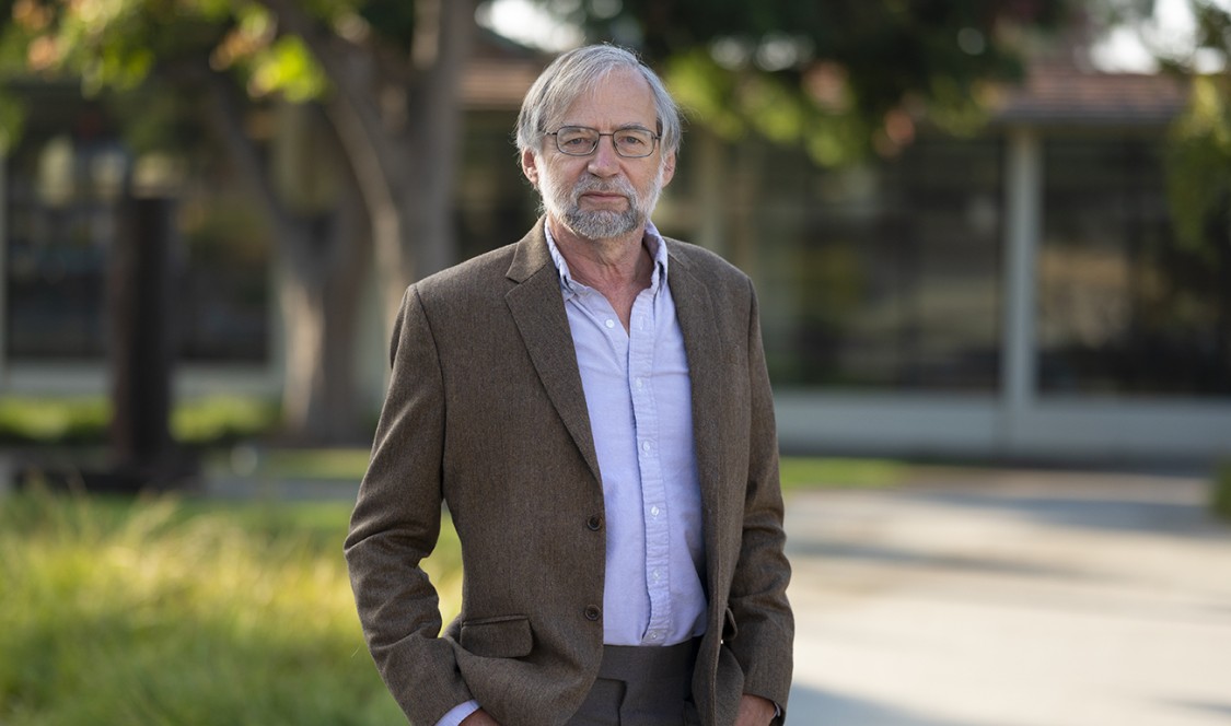 Portrait of a suited Professor Donald McFarlane on campus.