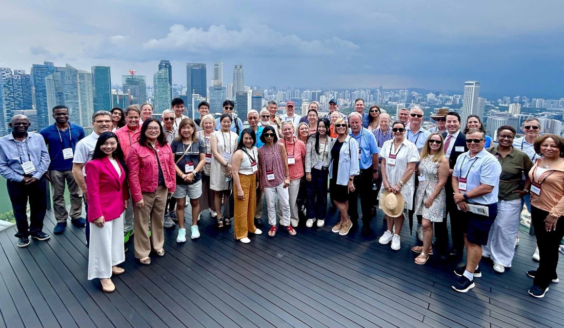 CMC Worldmeet Singapore group on building terrace.