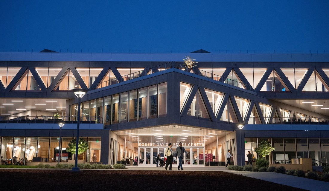 The Robert Day Sciences Center illuminated at night.