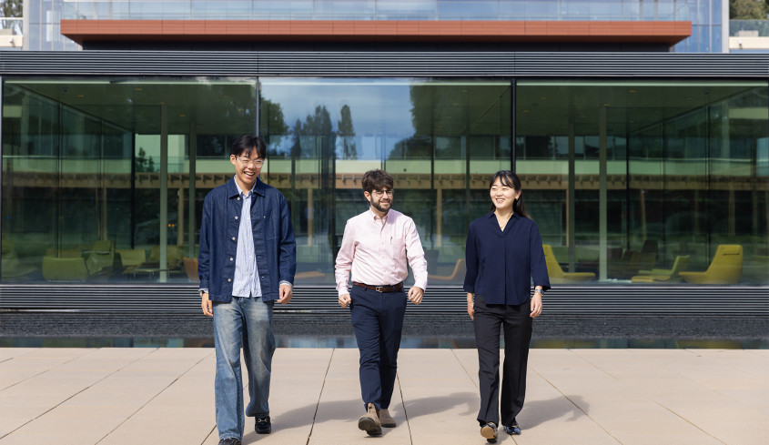 Brian Davidson '08, Daniel Wu '27 and Chisato Kamakura ’27 walking on campus