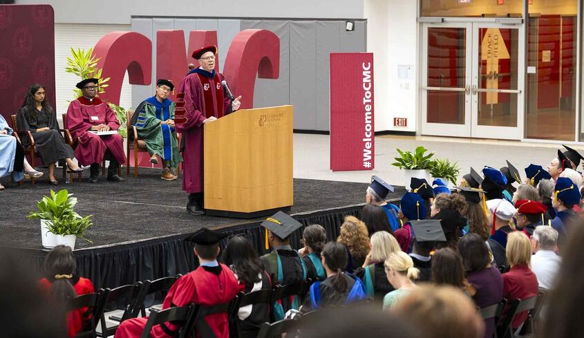 President Dudley at the podium in Roberts Pavilion during Convocation