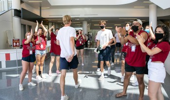 CMC students form a cheer tunnel inside Roberts Pavilion to welcome new students