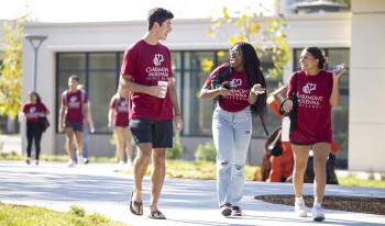 Students who arrived early to campus walk by Collins in their CMC maroon t-shirts.