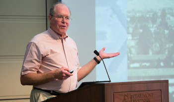 Prof. Elliott stands at a podium to deliver a lecture.