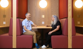 Prof. Ran Libeskind-Hadas and Prof. Heather Antecol sitting in booth at RDSC
