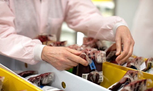 A technician handles blood donations at San Diego Blood Bank