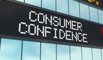 Digital screen displaying 'Consumer Confidence' and stock market rates.