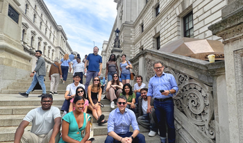 Students and staff sitting on stairs in front of Churchill War Room. 