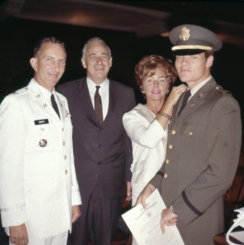 Three men in military uniforms and woman in white dress.