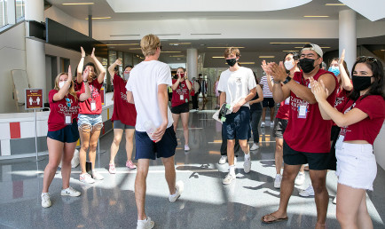 CMC students form a cheer tunnel inside Roberts Pavilion to welcome new students