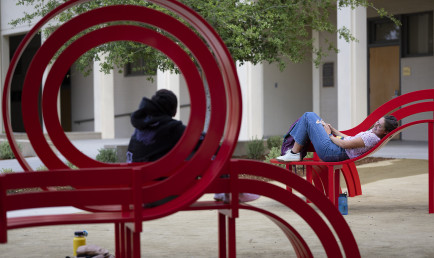 Students sit and lay down with their feet up on the newly revealed benches.