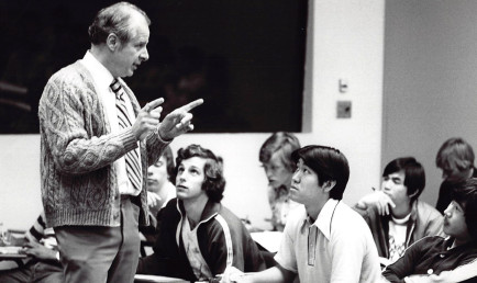 In a black and white photo, Professor John Ferling addresses his seated students during class.