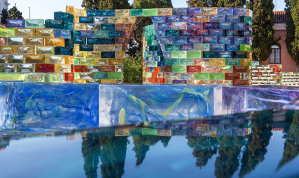 A close-up of the bricks shows polychromatic marbling within the glass. Behind is a frontal view of one of the hexagonal archways for Qwalala.